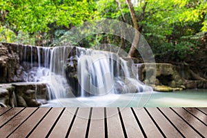 Wood table top on blurred waterfall rain forest