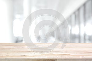 Wood table top on blurred white gray background of building hall