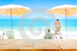 Wood table top on blurred white sand beach background