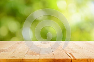 Wood table top on bokeh abstract green background