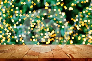 Wood table top with bokeh from decorative light on christmas tree in background