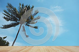 Wood table top on coconut tree and blue sky background.