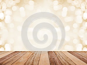 Wood table top over abstract golden background with white bokeh for Christmas and new year holidays. Montage style to display the