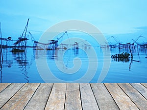 Wood table top over the dip net used for scooping fish in the sea