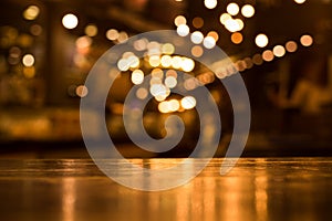 Wood table top with reflect on blur of lighting in cafe,restaurant photo