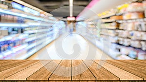 Wood table top with supermarket grocery store blurred defocused background with bokeh light for product display