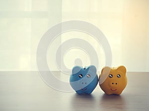 Wood table with two piggy bank on white drape texture background