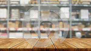 Wood table in warehouse storage blur background.