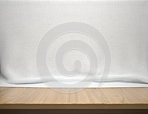 Wood table with white cotton fabric background