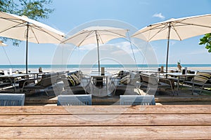 Wood tabletop on dining table with umbrella on the beach