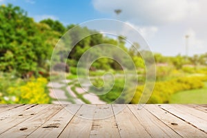 Wood tabletop and garden blurred with sunlight