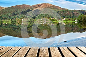 Wood Texture and Beautiful Summer Landscape Background with Green Trees, Mountains and Mirror Lake Reflection
