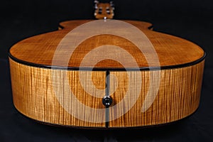 Wood texture of lower deck of six strings acoustic guitar on black background