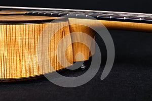 Wood texture of lower deck of six strings acoustic guitar on black background. guitar shape