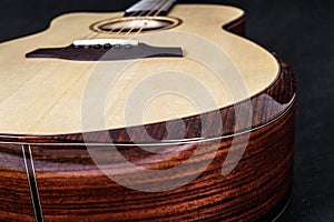 Wood texture of lower deck of six strings acoustic guitar on black background. guitar shape