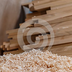 Wood timber construction material for background and texture. close up. wood shavings and Stack of wooden bars blurred on backgrou