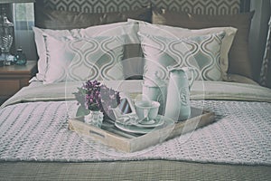 Wood tray of tea cup set on bed in bedroom interior