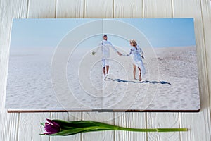 Wood wedding photo book. Happy young couple in love. Bride and groom walking of wedding day.