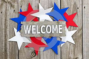 Wood welcome sign surrounded by red, white and blue stars