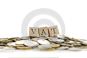 Wood word VAT is placed on a pile of coins.using as background business concept and finance concept with copy spaces