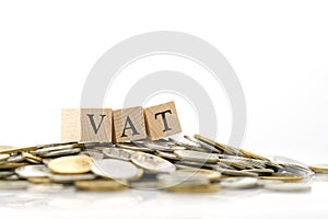 Wood word VAT is placed on a pile of coins.using as background business concept and finance concept with copy spaces photo