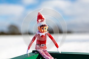 Woodbridge Suffolk UK February 11 2021: A close up of a naughty Christmas elf sitting outside in the snowy winter landscape