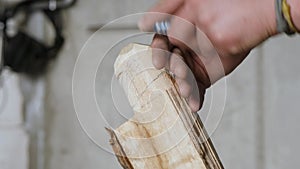 A woodcarver cuts a poplar product using a chisel. wood carving in a carpentry workshop. the art of wood carving and woodworking.