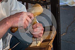 Woodcarver dressed in folk costume carves from wood