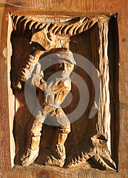 Woodcarving of man chopping tree photo