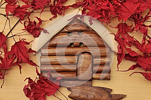 Woodcraft cabin house and dry maple leaves photo