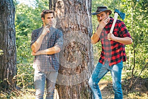 Woodcutters lumberjacks. Hipsters men on serious face with axe. Lumberjack brutal and bearded holds axe. Two lumberjacks