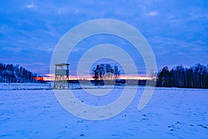 woode huntingtower in the middle of a snowy field