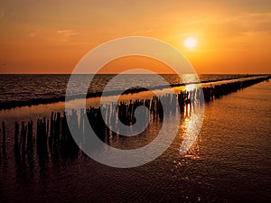 Wooded bridge pole in the port between sunrise against orange sky calm peaceful moment relax holiday concept idea background