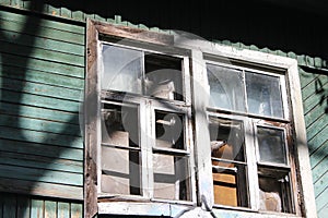 Wooden abandoned house without tenants. Old building. Broken window close-up