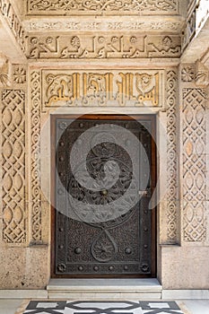 Wooden aged door with ornate bronzed floral patterns at the public mosque of Prince Mohammed Ali Tewfik Palace, Cairo, Egypt