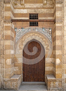 Wooden aged grunge door and stone bricks wall, one of the exterior doors of the Blue Mosque, Bab El-Wazir District, Cairo, Egypt