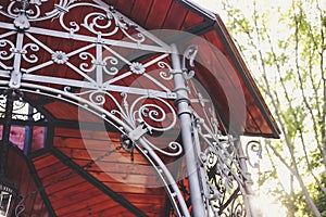 Wooden alcove ceiling with forged decorative elements in traditional style