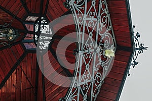 Wooden alcove ceiling with forged decorative elements in traditional style