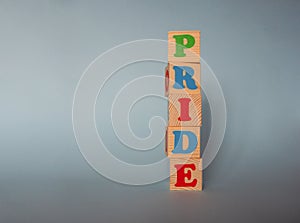 Wooden alphabet ABC toy blocks with the text: pride.