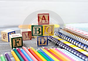 Wooden alphabet blocks on a white wooden background. Back to school, games for kindergarten, preschool education.