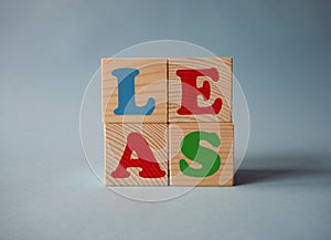 Wooden alphabet toy blocks with the counterclockwise text: sale. Isolated kids multi-colored ABC cubes on blue background