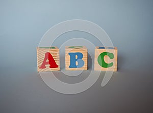 Wooden alphabet toy blocks with the text: abc. Isolated kids multi-colored ABC cubes