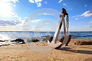 Wooden anchor near river on sunny day