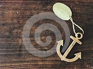 Wooden anchor on the vintage wooden table with natural light.