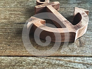 Wooden anchor on the vintage wooden table with natural light.