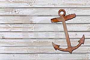Wooden anchor on the white wooden texture background