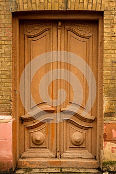 Wooden ancient Italian door in the historic center. Old European architecture. Two-fold wooden carved door. Vintage