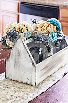 Wooden Antique Toolbox with Flowers on Farmhouse Table
