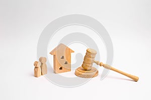 Wooden apartment house with people, keys and a judge hammer on a white background. The concept of laws and regulations for tenants