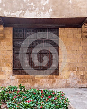 Wooden arabesque window, Mashrabiya, in exterior stone bricks wall of ottoman old historic building photo